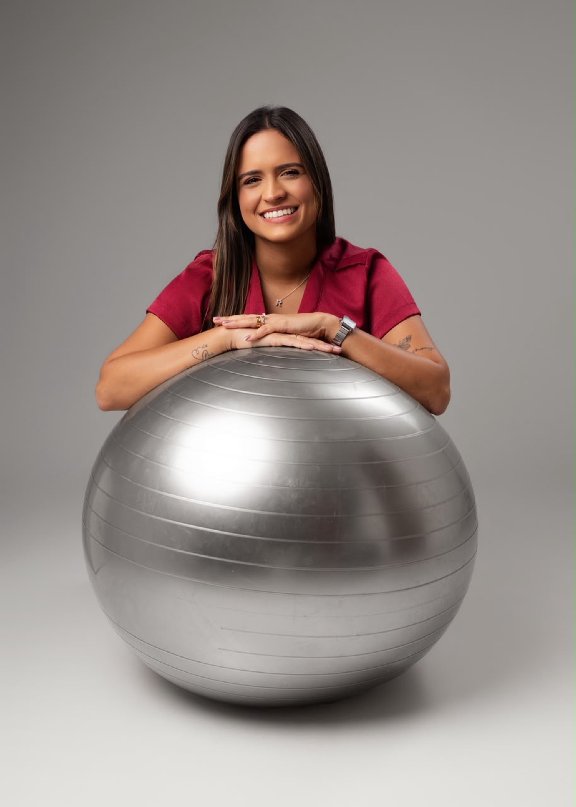 Rayssa apoiada em uma bola de pilates, sorrindo